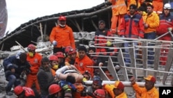 Rescue workers pull out a man from the rubble of a collapsed hotel in Van, eastern Turkey, November 10, 2011.
