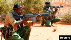 FILE - Kenyan policemen hold their position while patrolling the Kenya-Somalia border near the town of Mandera, Feb. 6, 2015. 