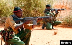 FILE - Kenyan policemen hold their position while patrolling the Kenya-Somalia border near the town of Mandera, Feb. 6, 2015.