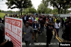 Marchers carry signs as they march to the Department of Justice during the 1,000 Ministers March for Justice in Washington, Aug. 28, 2017.