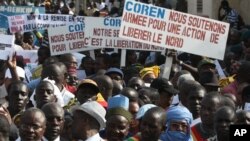 People originally from northern Mali carry signs reading 'We support army action to liberate the North,' as thousands of Malians, including elected officials, front, marched in support of foreign aid and military intervention to retake Mali's north from I
