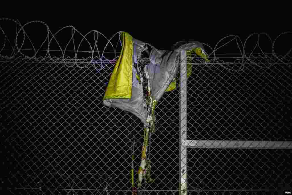 A torn sleeping bag remains atop the border fence in Asotthalom, Hungary, Sept. 15, 2015. (Gabor Ancsin / VOA)