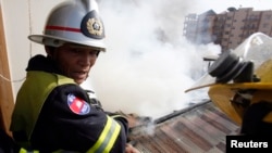 Fire fighters put out a fire on the roof of a building near the Russian market in Phnom Penh March 18, 2009. Twelve houses were destroyed in the blaze but no one was injured, police said. It is not known how the fire was started. REUTERS/Chor Sokunthea 