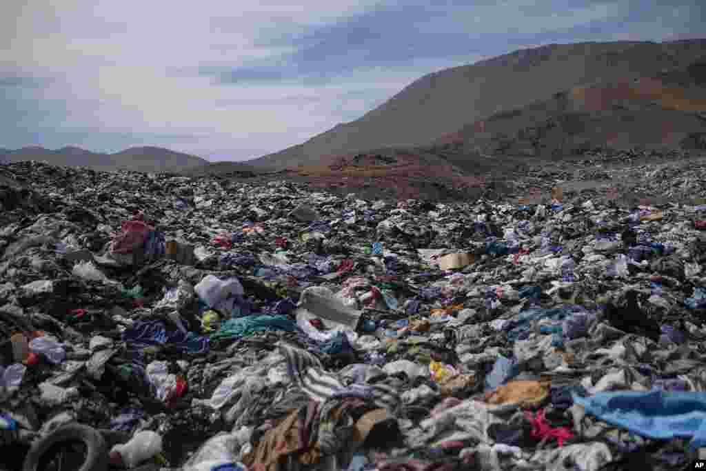 A large pile of second-hand clothing covers the sand near La Mula neighborhood in Alto Hospicio, Chile, Dec. 13, 2021.