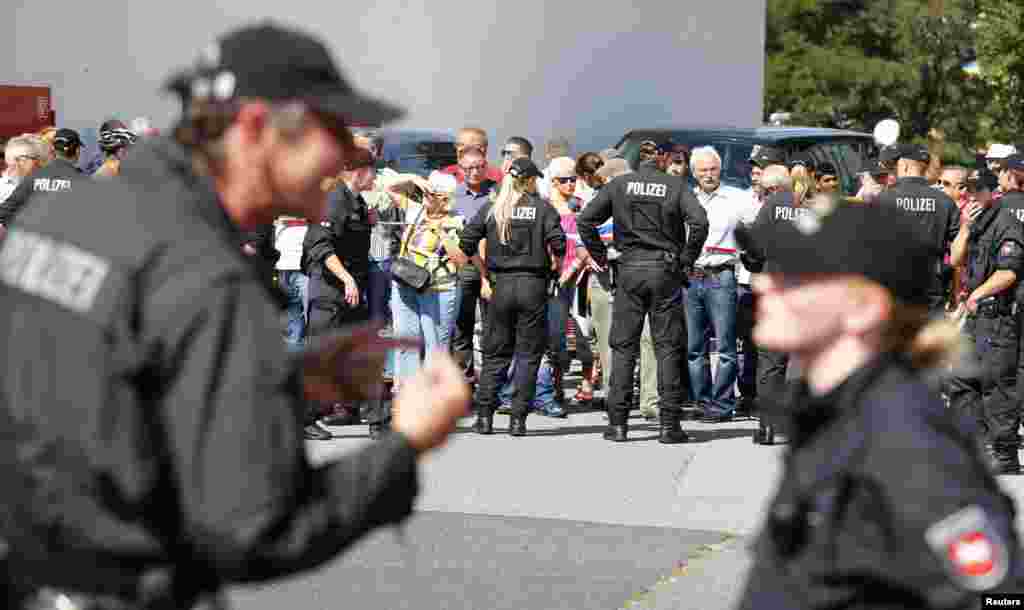 People gather near an asylum center during a visit of German Chancellor Angela Merkel, in the eastern German town of Heidenau, near Dresden, Aug. 26, 2015.