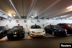 FILE - Tesla Model 3s and X's are shown charging in an underground parking lot next to a Tesla store in San Diego,California, U.S., May 30, 2018.
