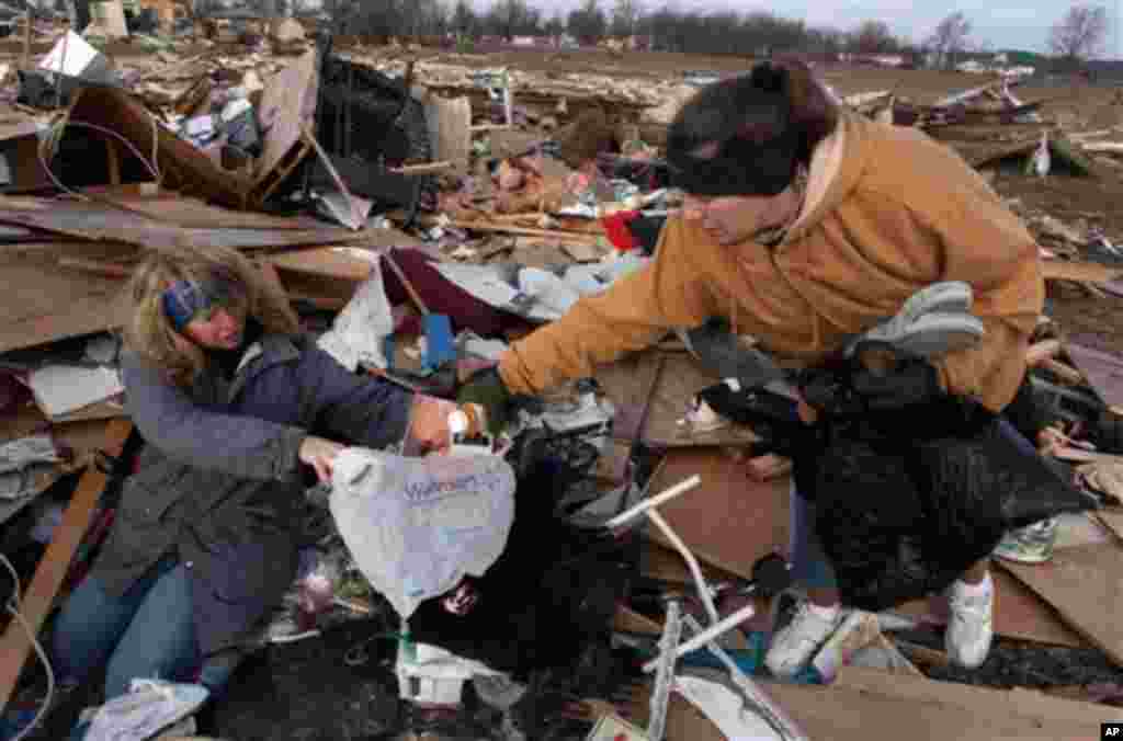 Unidentified women search through debris of Ted and Brenda Tolbert's Holton, Ind. home Sunday, March 4, 2012.