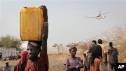 Para pengungsi Sudan Selatan membawa jerigen air di kamp pengungsi PBB di Malakal, Sudan Selatan. (AP/Ilya Gridneff)