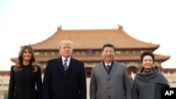 President Donald Trump, second left, first lady Melania Trump, left, Chinese President Xi Jinping, second right, and his wife Peng Liyuan, right, stand together as they tour the Forbidden City, Nov. 8, 2017, in Beijing, China.