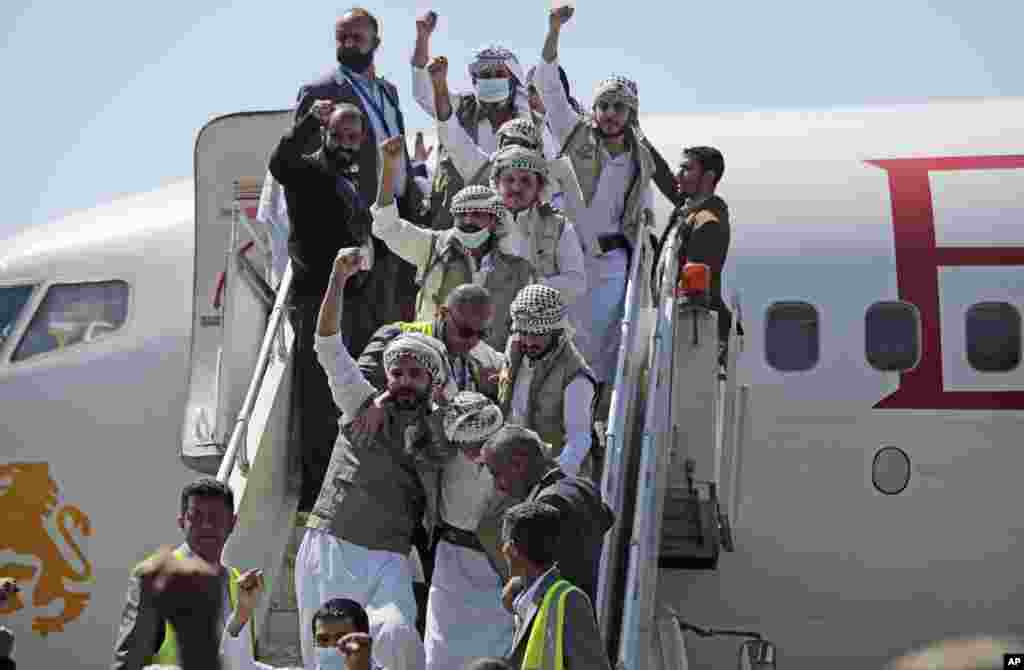 Yemeni prisoners chant slogans during their arrival after being released by the Saudi-led coalition at the airport in Sana&#39;a.