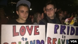 Attendees at the vigil hold signs in support of the victims of the Orlando attack. (K. Gypson/VOA)