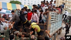 Cambodian migrant workers get off from a Thai truck upon their arrival from Thailand at a Cambodia-Thai international border gate in Poipet, Cambodia, Tuesday, June 17, 2014. The number of Cambodians who have returned home from Thailand this month after a threatened crackdown on foreigners working illegally has topped 160,000, a Cambodian official said Monday. Thai officials insist the cross-border movement is voluntary and is not forced repatriation. They say Thai military and government resources were used to transport workers who decided to return home after being laid off because they were working illegally. (AP Photo/Heng Sinith)