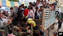 Cambodian migrant workers get off from a Thai truck upon their arrival from Thailand at a Cambodia-Thai international border gate in Poipet, Cambodia, Tuesday, June 17, 2014. 