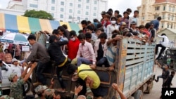 Cambodian migrant workers get off from a Thai truck upon their arrival from Thailand at a Cambodia-Thai international border gate in Poipet, Cambodia, Tuesday, June 17, 2014. The number of Cambodians who have returned home from Thailand.