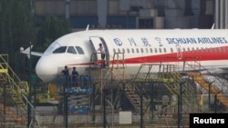 Workers inspect a Sichuan Airlines aircraft that made an emergency landing after a windshield on the cockpit broke off, at an airport in Chengdu, Sichuan province, China May 14, 2018. Picture taken May 14, 2018. REUTERS/Stringer