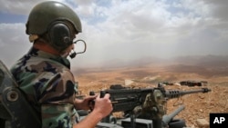 FILE - A Lebanese army soldier sits on a tank near the Syrian border, in northeast Lebanon. 