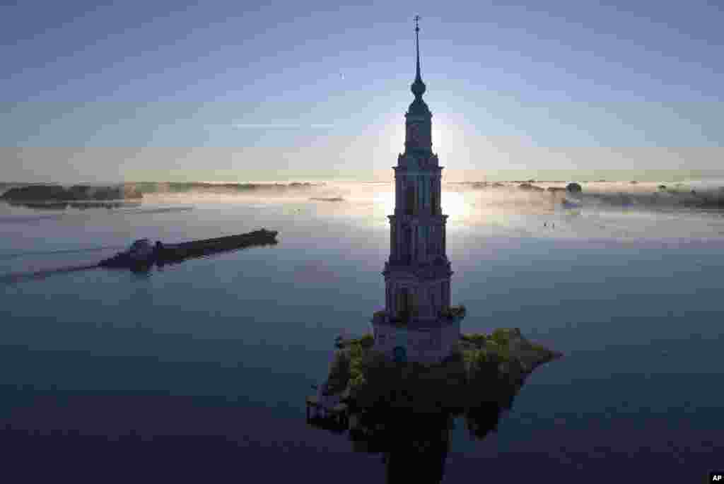 러시아 모스크바 인근 볼가강에서 수몰된 성 니콜라스 수도원의 캴라진 종탑 옆으로 화물선이 지나가고 있다. 소비에트연방 시절인 1939년 볼가강에 우글리치 댐을 건설하며 수도원을 포함한 중세 건축물들이 물 속에 잠겼다.