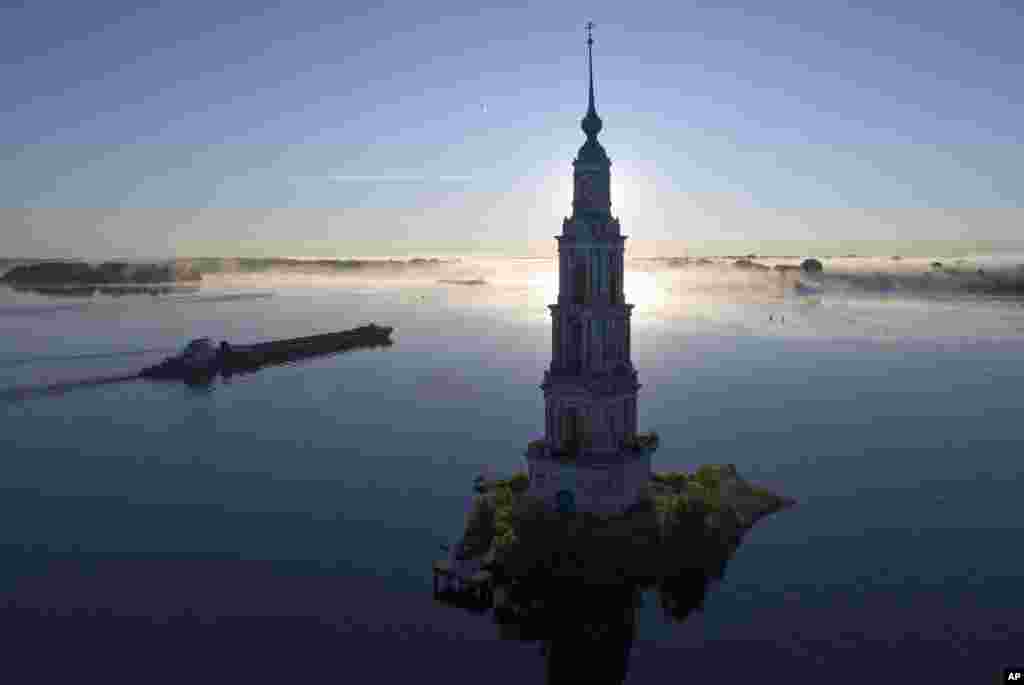 A cargo ship floats past the famous Kalyazin Bell Tower, part of the submerged monastery of St. Nicholas, in the town of Kalyazin located on the Volga River, close to Moscow, Russia.