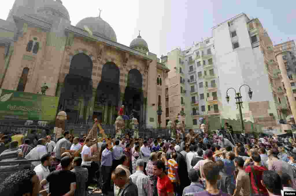 Wafuasi wa Morsi na polisi wa kupambana na ghasia wakusanyika nje ya mskiti wa al-Fath kwenye uwanja wa Ramses Cairo, August 17, 2013. 