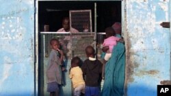 A south Sudanese woman gets supplies from a Nuba shop, 11 Jan 2011