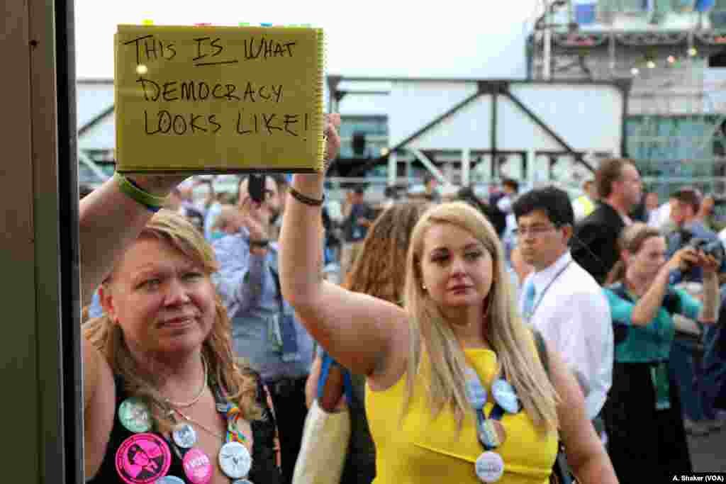 &quot;This is what democracy looks like,&quot; reads a protest sign held by a Bernie Sanders supporter after Hillary Clinton was formally nominated at the Democratic National Convention in Philadelphia, July 26, 2016. (A. Shaker/VOA)