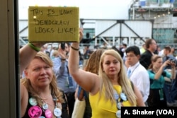 "This is what democracy looks like," reads a protest sign held by a Bernie Sanders supporter after Hillary Clinton was formally nominated at the Democratic National Convention in Philadelphia, July 26, 2016 (A. Shaker/VOA)