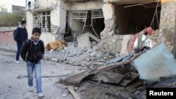 Students inspect a damaged house after a bomb attack in Kirkuk, 250 km (155 miles) north of Baghdad, December 17, 2012.