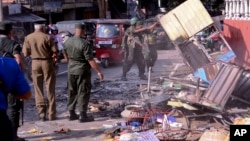 6일 스리랑카 캔디 외곽 디가나에서 무장 경찰들이 파손된 건물의 잔해를 치우고 있다. 