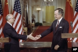 FILE - Soviet President Mikhail Gorbachev, left, and President George H. Bush shake hands following the signing of accords at the White House in Washington on Friday, June 1, 1990.