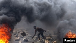 FILE - A protester sets up a barricade during a protest against Burundi President Pierre Nkurunziza and his bid for a third term in Bujumbura, Burundi, May 22, 2015.