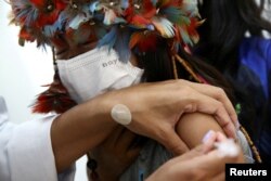 Indigenous child Laysa Kerexu Mirim, 7, receives a dose of the Pfizer-BioNTech COVID-19 pediatric vaccine in Sao Paulo, Brazil, Jan. 17, 2022.