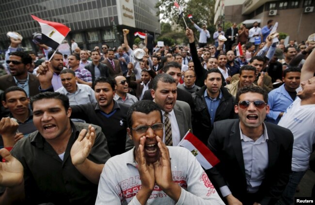 FILE - Unemployed graduates shout anti-government slogans during a protest to demand that the government offer them jobs, in front of the parliament headquarters in Cairo, March 27, 2016, where the nation's prime minister was speaking.