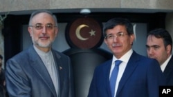 Menlu Iran Ali Akbar Salehi (kiri) dan Menlu Turki Ahmet Davutoglu sesaat sebelum pembicaraan terkait krisis Suriah di Ankara, Turki (7/8). 