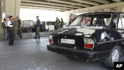 View of broken glass from a damaged police car at the site of a bomb blast in central Damascus April 27, 2012. 