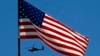 U.S. Army Apache helicopter flies past a flag on Observation Post Mustang in Afghanistan's Kunar Province, June 4, 2012 file photo.