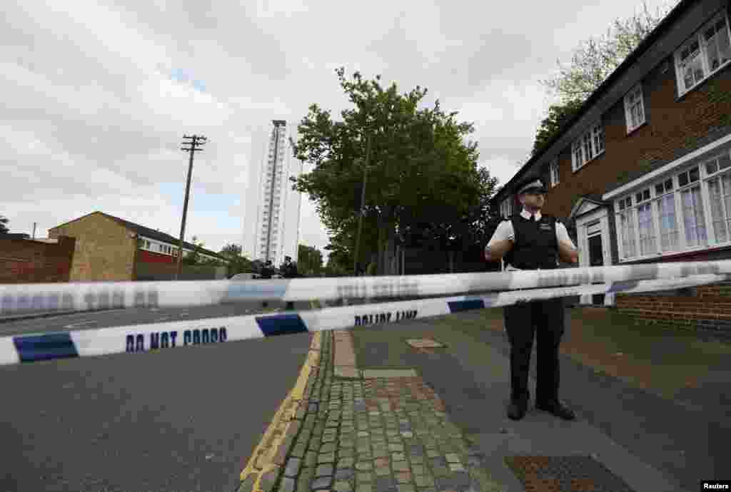 Police officers guard a cordon set up around a crime scene where one man was killed was killed in Woolwich, southeast London May 22, 2013.