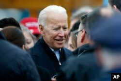 FILE - Former vice president Joe Biden talks with officials after speaking at a rally in support of striking Stop & Shop workers in Boston, April 18, 2019.