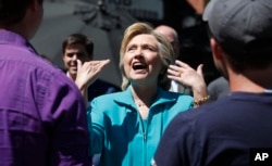 Democratic presidential nominee Hillary Clinton talks with volunteers registering voters outside the Hub Coffee Roasters in Reno, Nev., Aug. 25, 2016.