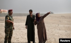 Civilians help Iraqi troops after the liberation of Khalidiya village from Islamic State militants south of Mosul, Iraq, Oct. 20, 2016.