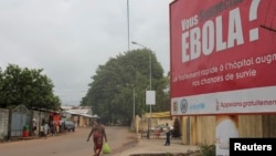 FILE - A billboard with a message about Ebola appears on a street in Conakry, Guinea, Oct. 26, 2014.