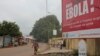 FILE - A billboard with an Ebola message looms over a street in Conakry, Guinea, Oct. 26, 2014.