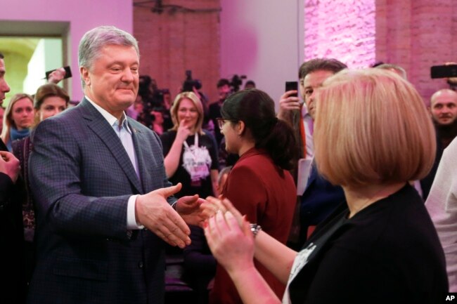 Ukrainian President Petro Poroshenko greets his supporters as he arrives at his headquarters after the presidential election in Kyiv, March 31, 2019.