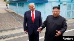 도널드 트럼프 미국 대통령과 김정은 북한 국무위원장이 지난 6월 군사분계선을 넘어 판문점 남측으로 넘어온 후 기자들과 이야기하고 있다. 