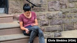 After injecting herself with heroin, a woman in a comatose state sits on the stairs of Prevention Point.