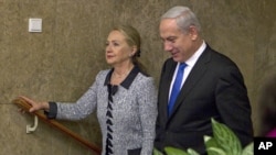  Premye Minis Izrayèl la, Benjamin Netanyahu, ap mache bò kote Sekretè Deta ameriken an, Hillary Rodham Clinton, anvan yon rankont nan Jerizalèm, (20 novanm 2012). 