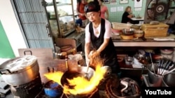 Chef Fai Junsuta cooks at her street restaurant Jay Fai in Bangkok, Thailand. (YouTube)