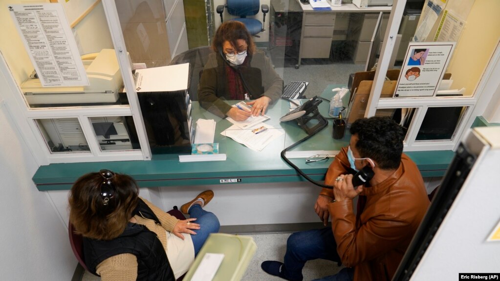 Mohammad Attaie and his wife Deena, newly arrived from Afghanistan, get help from medical translator Jahannaz Afshar making a doctor's visit at the Valley Health Center TB/Refugee Program in San Jose, California, on December 9, 2021. (AP Photo/Eric Risberg)