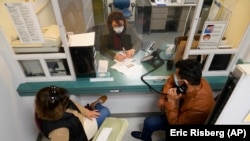 Mohammad Attaie and his wife Deena, newly arrived from Afghanistan, get help from medical translator Jahannaz Afshar making a doctor's visit at the Valley Health Center TB/Refugee Program in San Jose, California, on December 9, 2021. (AP Photo/Eric Risberg)