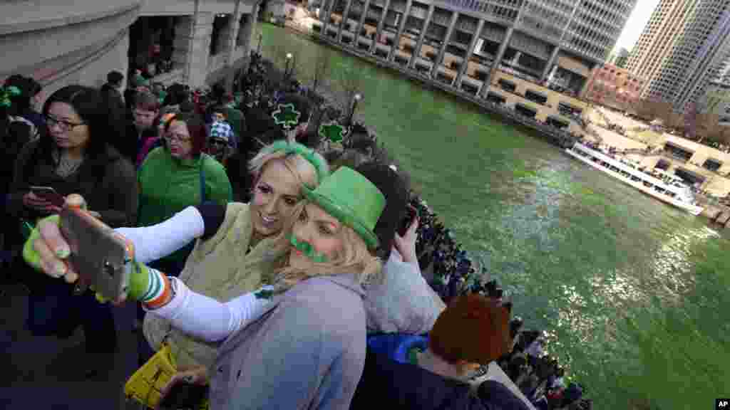 Alex Nowakowska, à gauche, et Joanna Puchlik, à droite, toutes de Chicago, se prennent une photo (Selfie) après à coté de la rivière Chicago teinte en verte avant la parade de la Saint-Patrick à Chicago,&nbsp; le 14 Mars 2015.