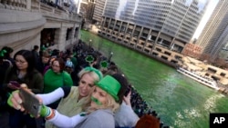 Chicago residents take a selfie after the Chicago River is dyed green ahead of the St. Patrick's Day parade.